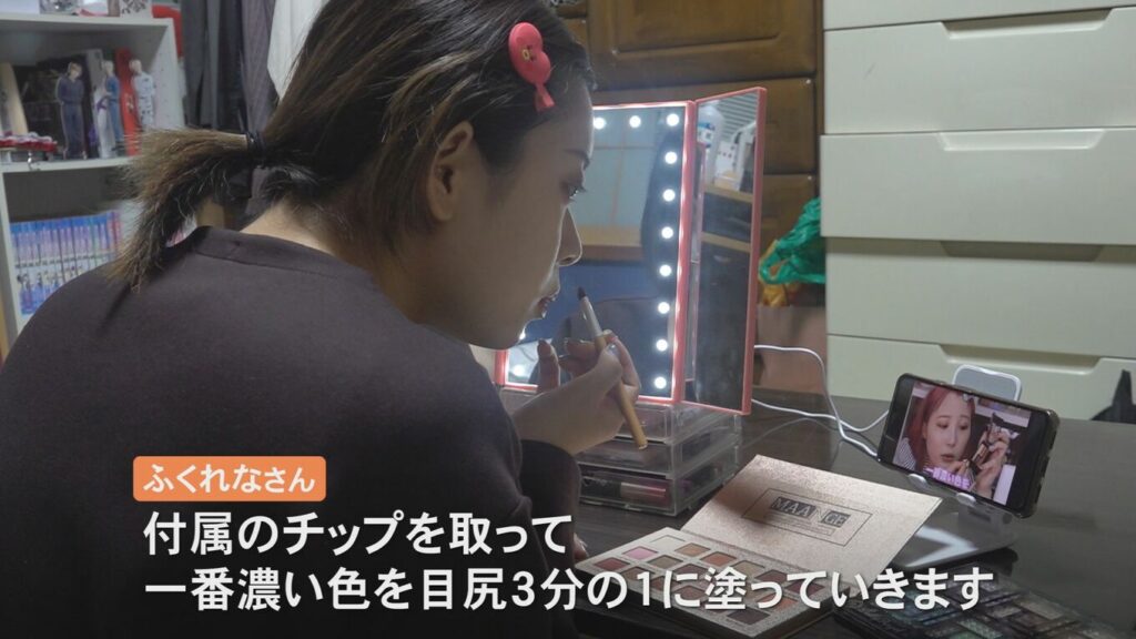 Nakajima vừa trang điểm vừa xem video - Ảnh: TBS